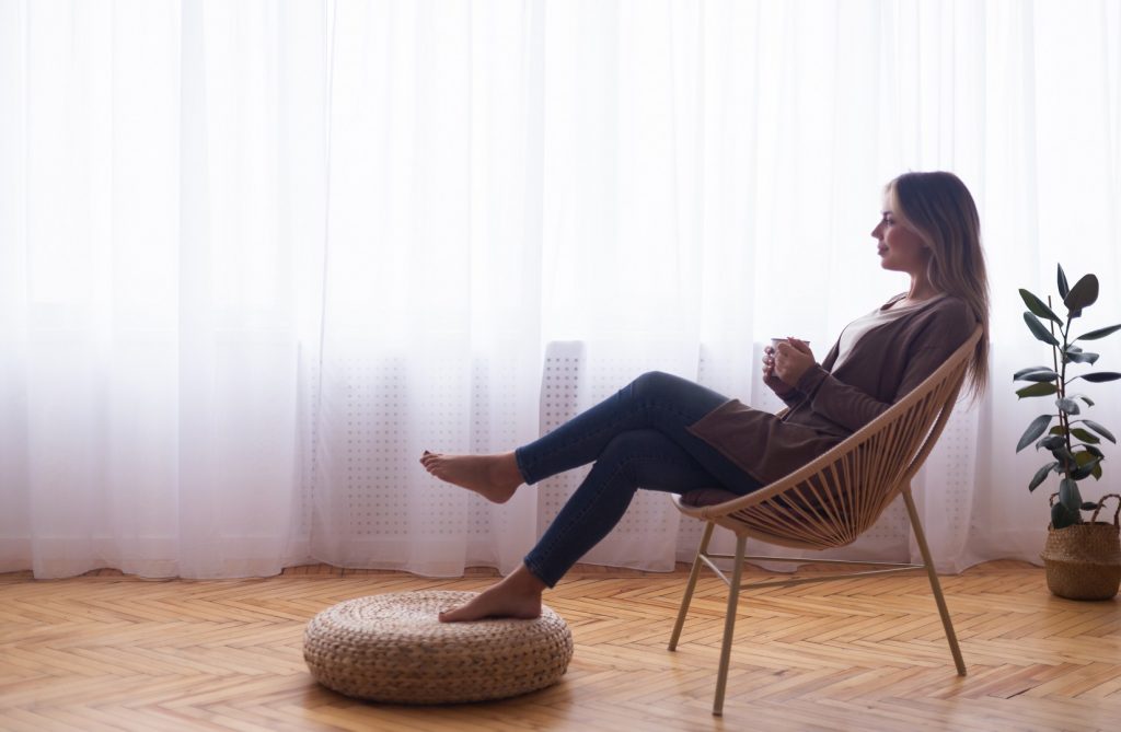 Dreaming mood. Peaceful woman enjoying hot coffee near window at home, empty space